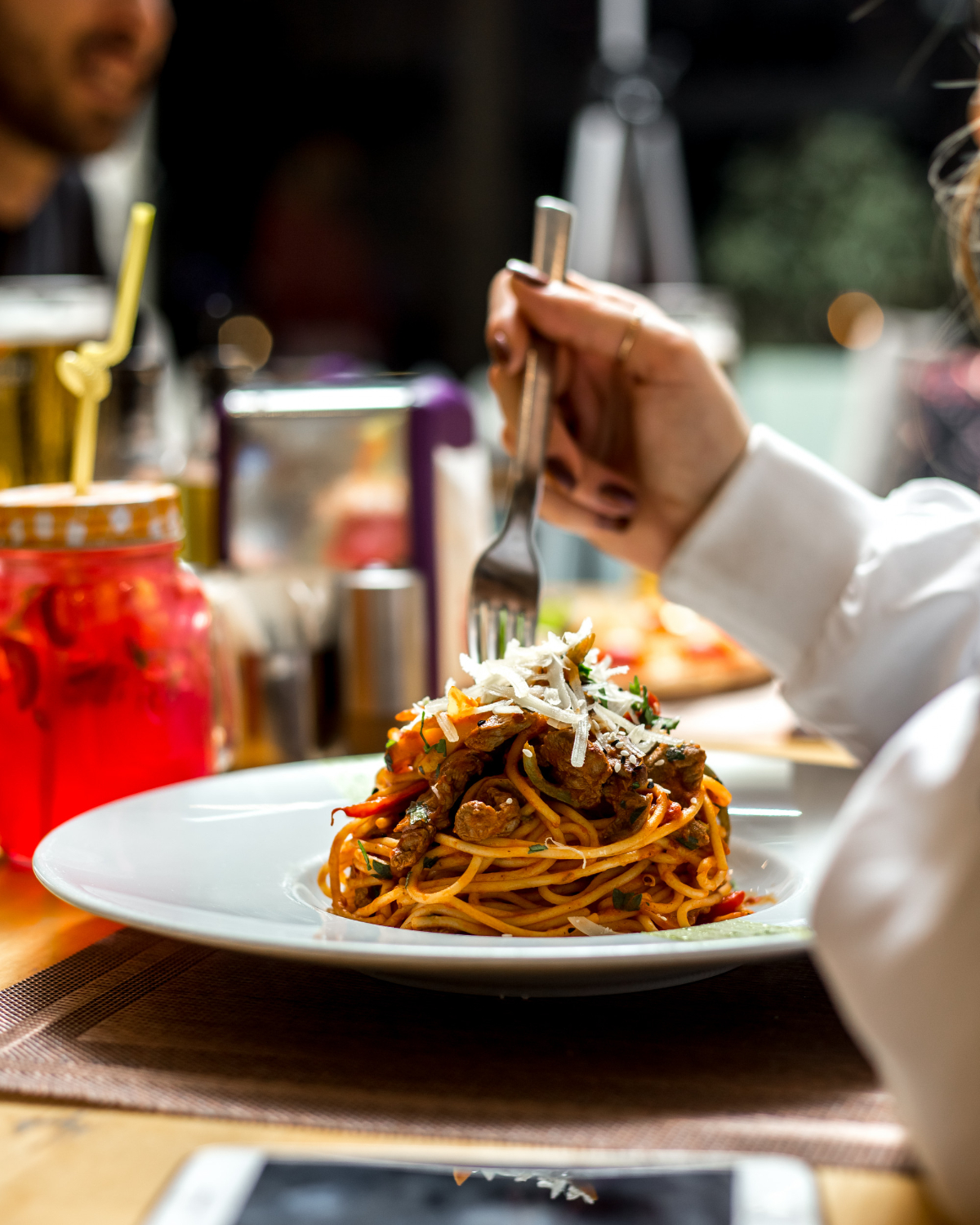la-donna-mangia-gli-spaghetti-della-pasta-con-la-vista-laterale-del-parmigiano-di-verdi-di-carne